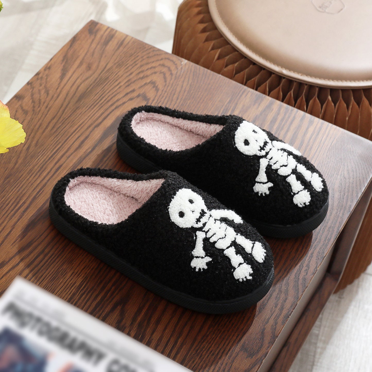 Black slippers with skeleton design on a wooden surface