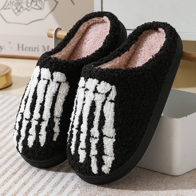 Black and white skeleton design slippers on a neutral background